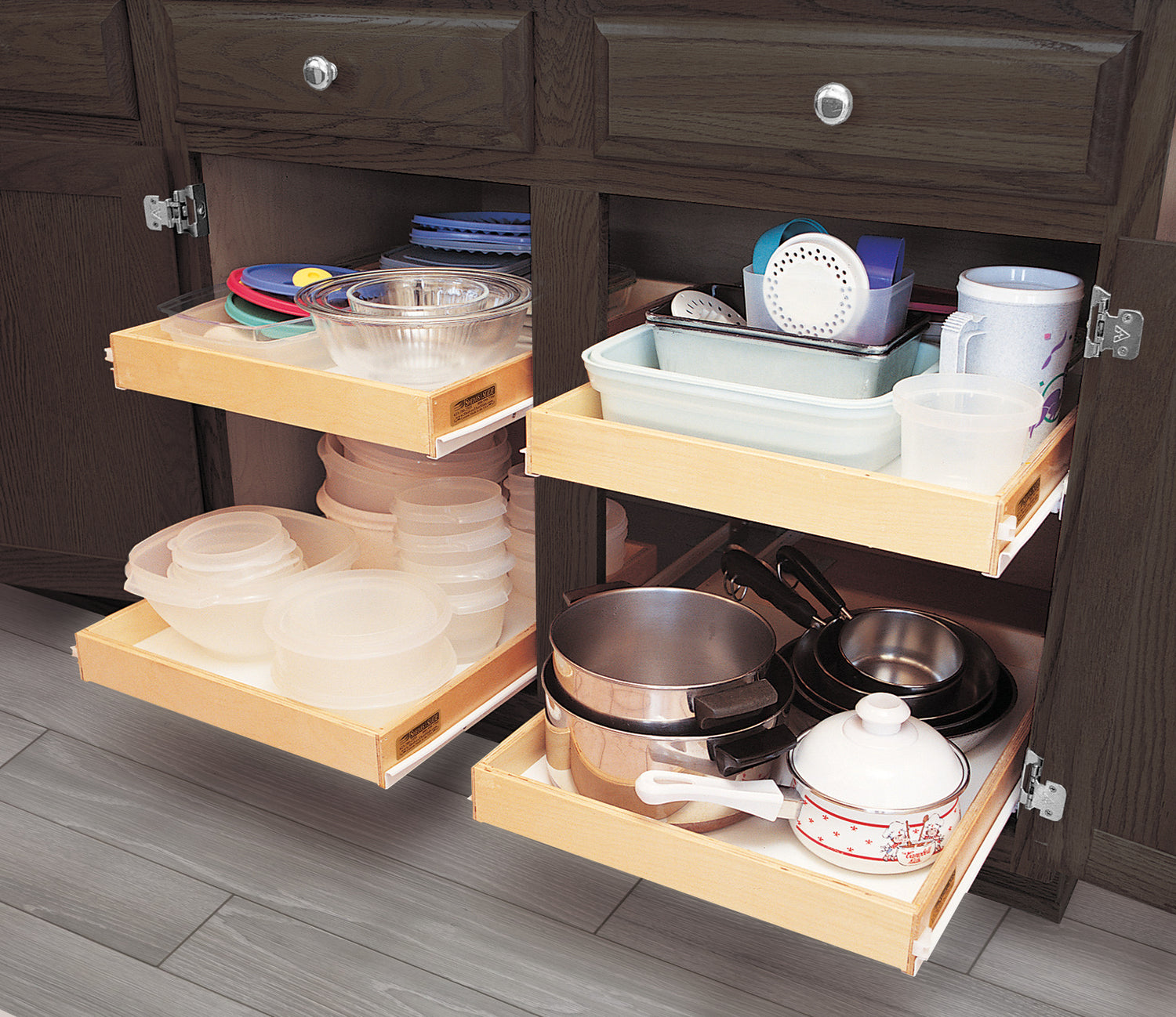 Kitchen cabinet with custom pull-out sliding shelves organized with plastic containers, pots, and dishes.
