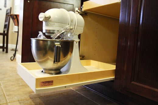 Heavy kitchen mixer placed on custom pull-out shelf to demonstrate shelf strength and cabinet storage efficiency.